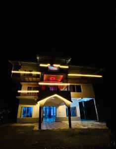 a building with a sign on the front of it at night at Hotel Chandra Paradise in Munsyari