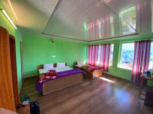 a bedroom with green walls and a bed with purple sheets at Hotel Chandra Paradise in Munsyari