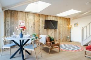 a living room with a table and a tv at The Barn at Thorpewood in Thorpe Market