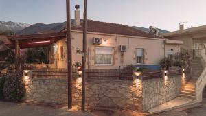 a house with a stone fence and lights on it at The Morus House with Private pool in Melidhónion
