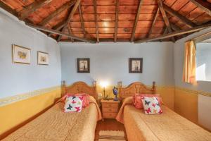 a bedroom with two beds and a wooden ceiling at Casa Asuncion in Breña Alta
