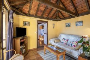 a living room with a couch and a tv at Casa Asuncion in Breña Alta