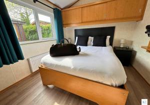 a bedroom with a large bed with a bag on it at Rupert's Lodge in West Down