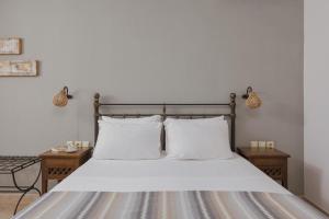 a bedroom with a bed with white sheets and pillows at Niriides Luxury Apartments in Syvota
