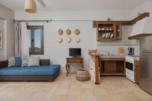 a living room with a blue couch and a kitchen at Niriides Luxury Apartments in Syvota