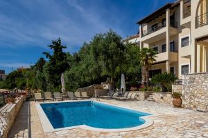 a swimming pool in front of a house at Niriides Luxury Apartments in Syvota