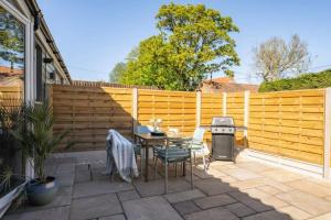 a patio with a table and chairs and a fence at The Cove at Thorpewood in Thorpe Market