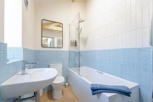 a bathroom with a sink and a tub and a toilet at The Cove at Thorpewood in Thorpe Market