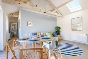 a dining room with a table and a couch at The Cove at Thorpewood in Thorpe Market