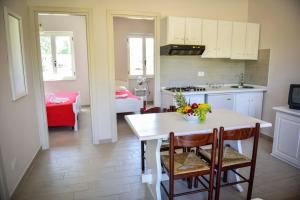 eine Küche und ein Esszimmer mit einem Tisch und Stühlen in der Unterkunft Marina di Rossano Village Club in Rossano