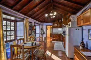 a kitchen and dining room with a table and a refrigerator at Casa Asuncion in Breña Alta