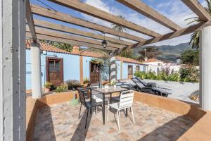 a patio with a wooden pergola and a table and chairs at Casa Asuncion in Breña Alta