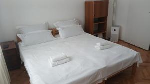 a white bed with two white towels on it at Pozarevac-Centar-Stan in Požarevac