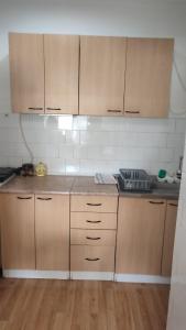 a kitchen with wooden cabinets and a counter top at Pozarevac-Centar-Stan in Požarevac