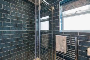 a bathroom with black tiled walls and a window at Kenton in Newquay +48 photos