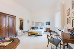 a living room with a bed and a desk and a table at Dimora Dell'Erbe Apartments in Montepulciano