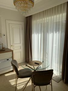 a dining room with a glass table and two chairs at Vaineikio 8 in Palanga