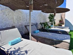 a group of beds sitting under an umbrella at Villa Massalia Essaouira in Essaouira