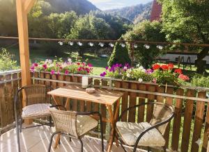 a table and chairs on a balcony with flowers at Apartmán U ŘEKY in Srbsko