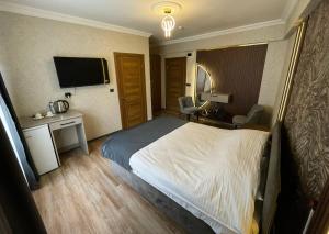 a hotel room with a bed and a desk and a television at Kütahya Şehir Otel in Kütahya +37 photos