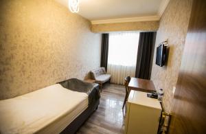 a hotel room with a bed and a couch and a tv at Kütahya Şehir Otel in Kütahya