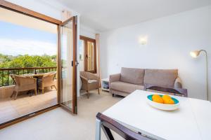 a living room with a couch and a table with a bowl of oranges at Cala Figuera Apartment 4b in Cala Figuera