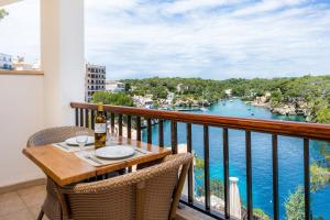 a table on a balcony with a view of the water at Cala Figuera Apartment 4b in Cala Figuera
