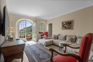 a living room with a couch and a table at Les Pigerolles de Cabris in Cabris