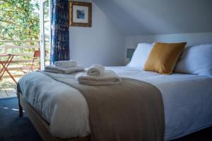 a bedroom with a bed with towels on it at Saltspring Lodge in Oban