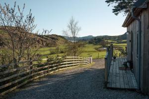 a wooden fence next to a building with a gate at Saltspring Lodge in Oban