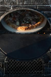 a pizza sitting on a plate in an oven at Saltspring Lodge in Oban