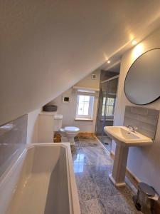 a bathroom with a tub and a sink and a toilet at Saltspring Lodge in Oban +14 photos