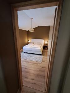 a view of a bedroom with a white bed at DolomitiBel Garibaldina in Belluno