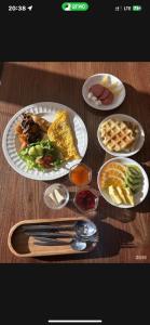 a wooden table with plates of food on it at Asmanguesthouse in Naryn