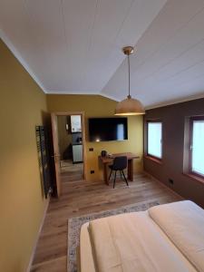 a bedroom with a bed and a desk and a tv at DolomitiBel Garibaldina in Belluno