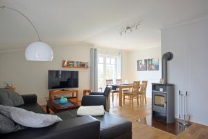 a living room with a black couch and a table at Strandvilla Börgerende in Börgerende-Rethwisch