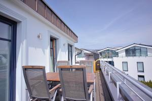 a balcony with a wooden table and chairs on it at Strandvilla Börgerende in Börgerende-Rethwisch