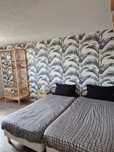 a bedroom with a bed in front of a wall at Le repaire des 6 Manalas in Ingersheim