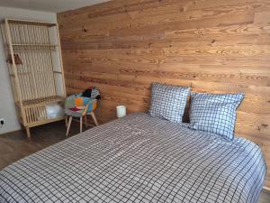 a bedroom with a bed and a wooden wall at Le repaire des 6 Manalas in Ingersheim