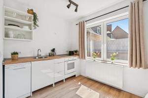 a kitchen with white cabinets and a large window at Boardinghouse Rees in Rees +18 photos