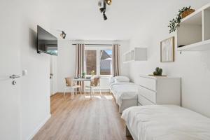 a bedroom with two beds and a dining room at Boardinghouse Rees in Rees