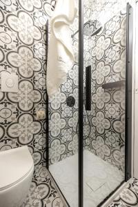 a bathroom with a toilet and a glass shower door at Aria d'amare in Mola di Bari