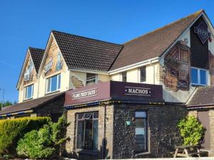 a building with a sign for a restaurant at Rupert's Lodge in West Down