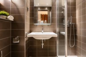 a bathroom with a sink and a shower at L'Adresse in Paris