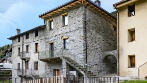 an old stone building with stairs on it at Chalet Ferrari in Ponte di Legno