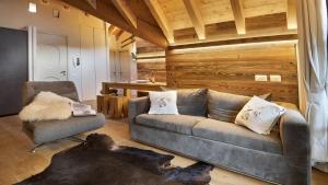 a living room with a couch and a chair at Alpen Chalet in Ponte di Legno