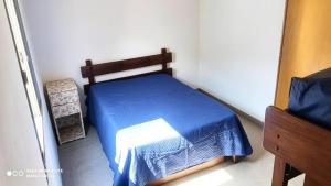 a bedroom with a bed with a blue comforter at Casa Ubatuba in Ubatuba