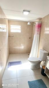 a bathroom with a toilet and a shower at Casa Ubatuba in Ubatuba