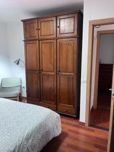 a bedroom with a large wooden cabinet next to a bed at El Isleño in Valverde +5 photos