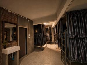 a bathroom with a sink and a mirror at TUKTUK Home in Samphanthawong